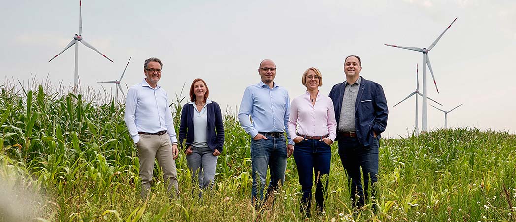 Kunden und Kundenberater vor Windrädern