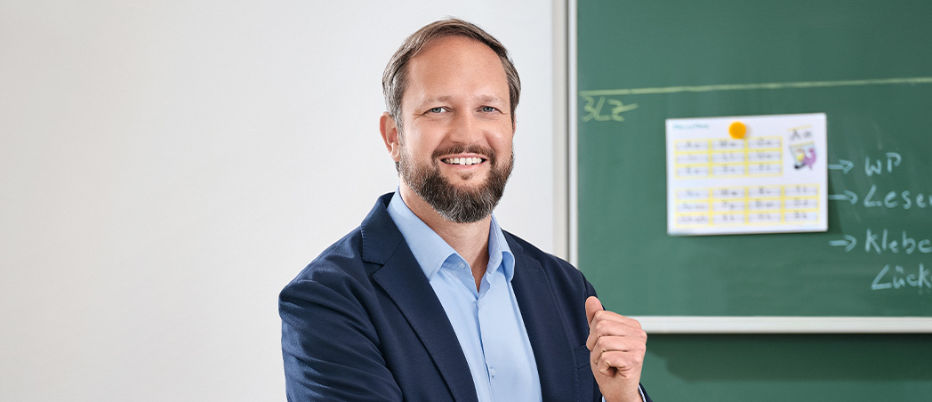 Steffen Siegert vor einer Tafel im Klassenzimmer