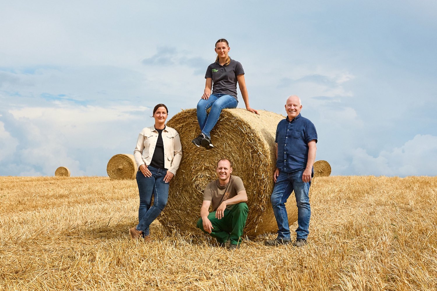 Kunden und Kundenberater vor einem Heuballen
