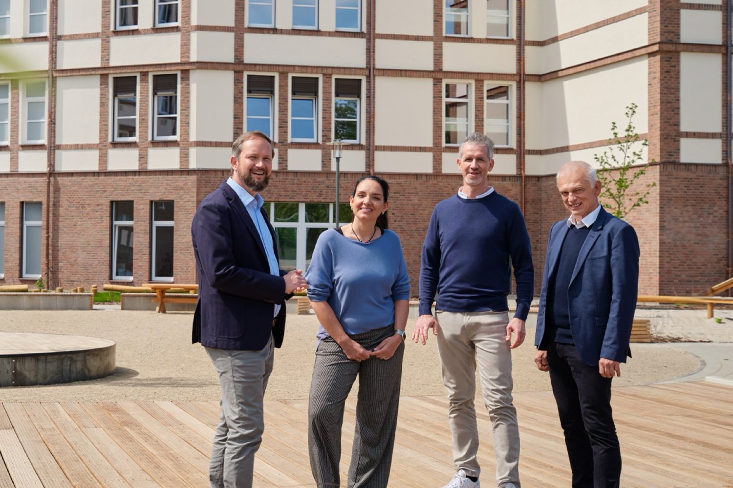 Kund*innen stehen vor dem Schulgebäude