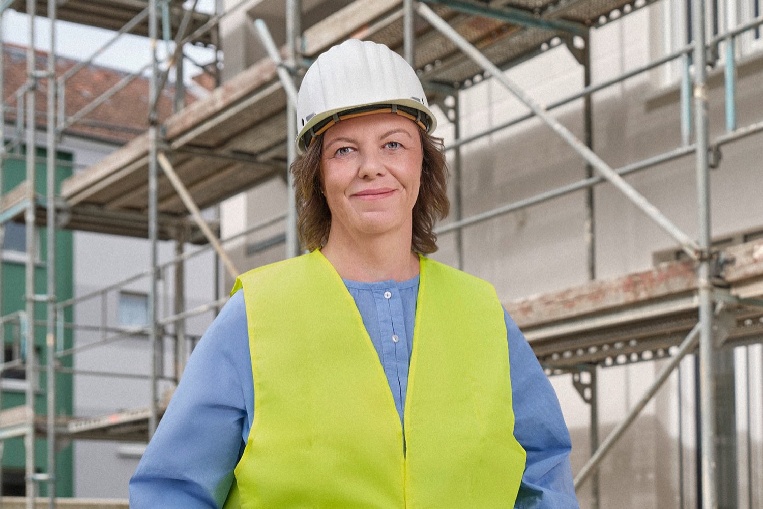 Cora Lehnert von der Wohnbaugenossenschaft vor einem Gebäude