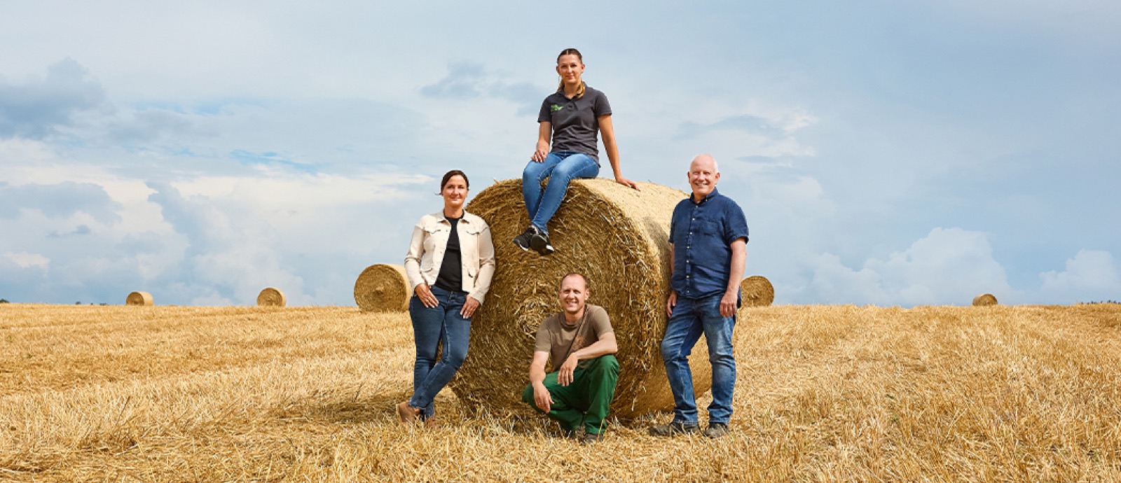 Kunden und Kundenberater vor einem Heuballen