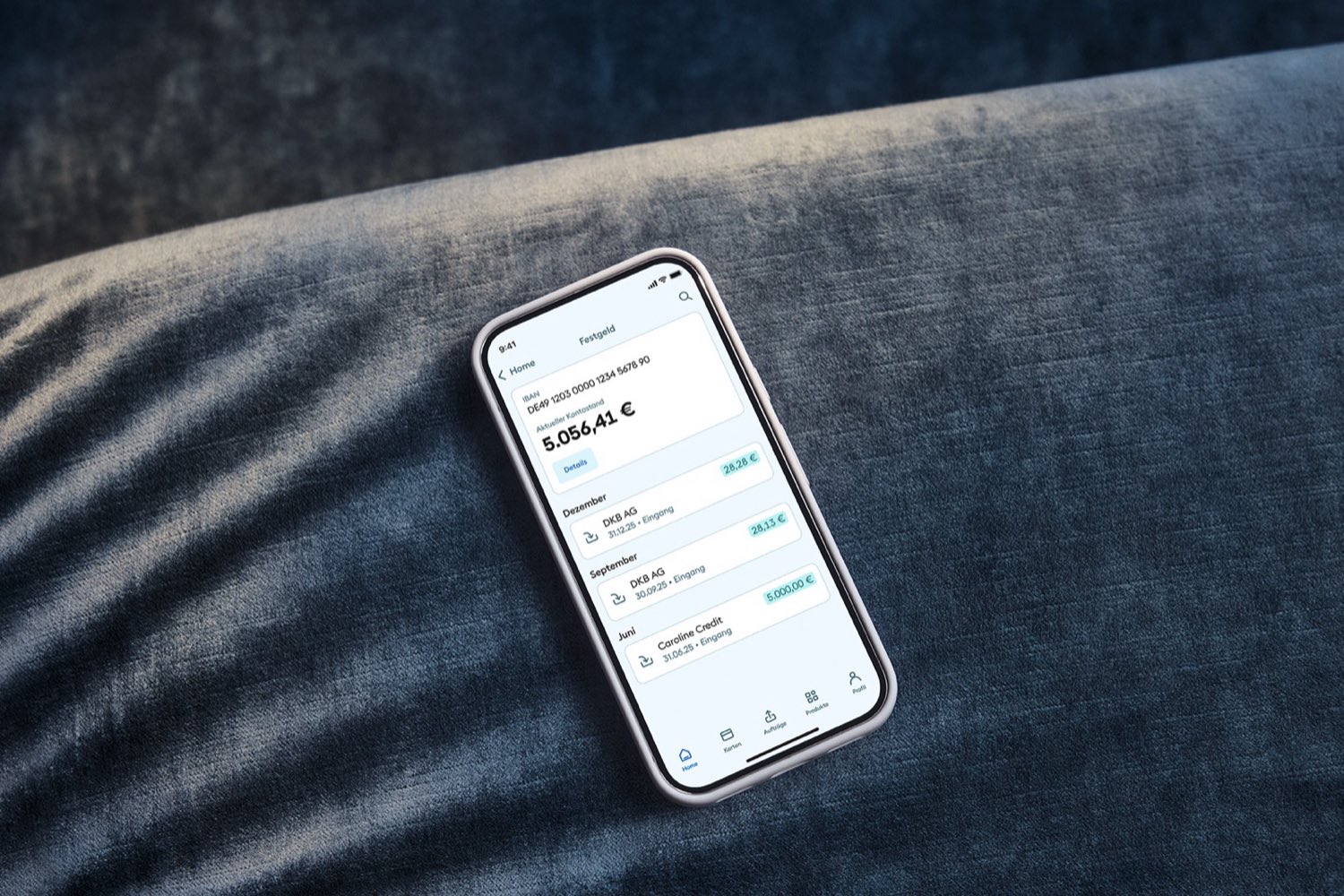 Ein Mobiltelefon mit dem Festgeld der DKB liegt auf einer Couch